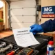 Tu00e9cnico con guante azul muestra un presupuesto de reparaciu00f3n de puerta de garaje accesible en Valencia, junto a sus herramientas.